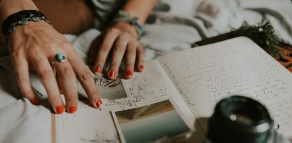 person with hand on notepad page with pictures and writing